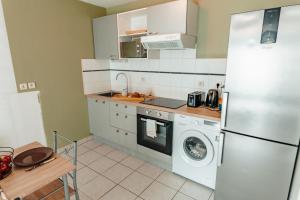 cocina con nevera y lavadora en Apparthotel - Horizon Poitevin en Poitiers