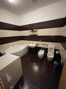 La salle de bains est pourvue de 2 lavabos, d'une baignoire et de toilettes. dans l'établissement MAK Apartments, à Tirana