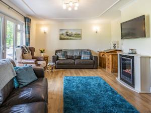a living room with a couch and a fireplace at Yr Hen Ffald in Llanedy