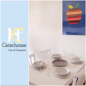 a table with plates and glasses and an apple picture at Carachouse-Lido di Camaiore, tra pini marini e mare in Lido di Camaiore