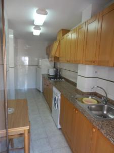a kitchen with a sink and a washing machine at Apartamentos Pescadores in Peniscola