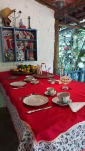a table with a red table cloth and plates on it at Monte Carmelo Inn Sana in Sana
