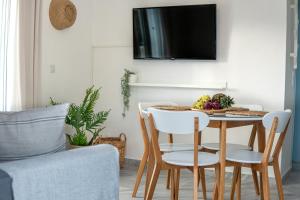 - un salon avec une table, des chaises et une télévision dans l'établissement Andrikas Villa at Xenios Avlais, à Zante