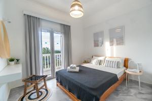 a bedroom with a bed and a large window at Andrikas Villa at Xenios Avlais in Zakynthos Town
