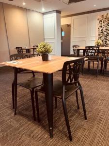 una mesa de madera y sillas en una sala de conferencias en John Hunter Motel Muswellbrook en Muswellbrook