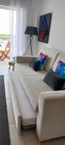 a couch with pillows in a living room at Apartamentos Dom Henrique in Monte Gordo