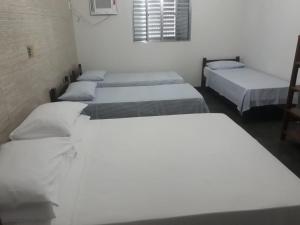 fila de camas en una habitación en Pousada Orla do Sol, en Prado