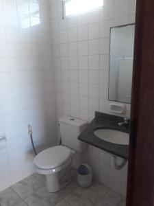 ein Badezimmer mit einem weißen WC und einem Waschbecken in der Unterkunft Pousada Orla do Sol in Prado