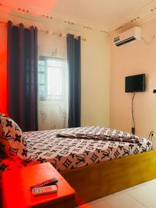 a small bedroom with a bed and a window at Residence SVET in Kribi