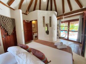 a bedroom with a large bed and a large window at Casa Cacahuate Holbox-Casa entera con jardin-Whole house with garden in Holbox Island