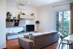 Una sala de estar con un sofá y un televisor. en Acquamarina Luxury House, en Aci Castello