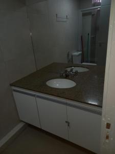 a bathroom with a sink and a mirror at Apartamento 1011 in Goiânia