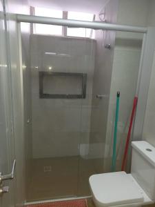 y baño con ducha de cristal y aseo. en Apartamento 1011 en Goiânia