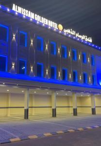 a building with blue lights on the side of it at فندق الوسام الذهبي in Al Ḩanākīyah