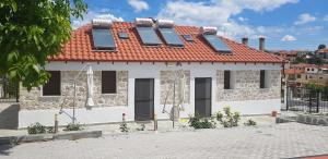 a white house with a red roof and windows at Olympia studios By Travel Pro Services - Agios Nikolaos Halkidiki in Ayios Nikolaos Sithonia