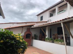 a white house with a porch and some plants at Pousada da Rita in Lençóis