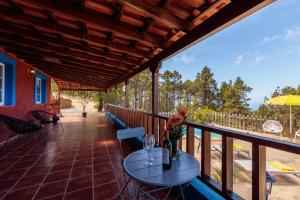 a patio with a table and chairs on a deck at La Casita. Atardeceres en Puntagorda in Puntagorda