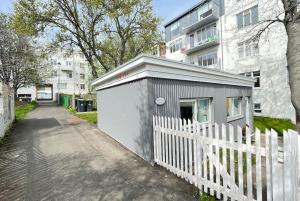 a small shed next to a fence next to a building at Charming cottage in downtown Reykjavik - Birta Rentals in Reykjavík