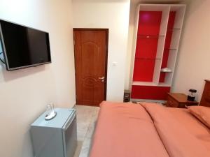 a living room with a bed and a flat screen tv at RÉSIDENCE HÔTELIÈRE KAWEROU in Ouagadougou