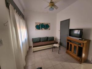 Una sala de estar con un sofá y un televisor. en Departamentos HF, en Villa María