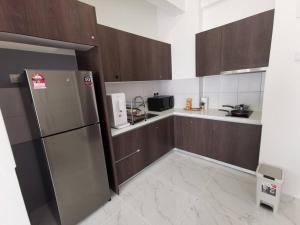 uma cozinha com armários de madeira e um frigorífico de aço inoxidável em Eternity Live2@ Troika Residence Kota Bharu-1B4Pax em Kota Bharu