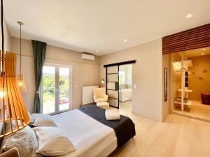 a bedroom with a large bed and a chair at Elysian Studios in Roda
