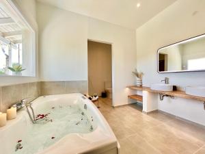 a bathroom with a bath tub and a sink at Elysian Studios in Roda