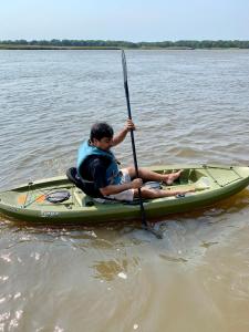 a man sitting on a kayak in the water at Sai Rakshit Villa on Maurice River in Millville