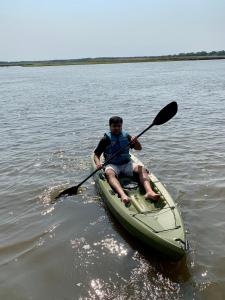 un homme est en kayak dans l'eau dans l'établissement Sai Rakshit Villa on Maurice River, à Millville