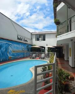 a swimming pool in front of a building at Hotel ilama in Buga