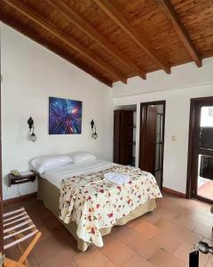 1 dormitorio con 1 cama con una pintura en la pared en Hotel ilama, en Buga