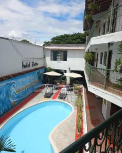 vistas a la piscina desde el balcón de un hotel en Hotel ilama, en Buga