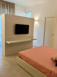 a bedroom with a bed and a flat screen tv at B&B LE MAGNOLIE in Termoli