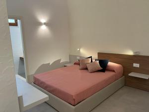 a bedroom with a bed with orange sheets and pillows at B&B LE MAGNOLIE in Termoli