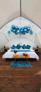 a room with a bed in a tent with blue balloons at Origen Glamping en Villa de Leyva in Villa de Leyva