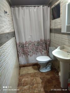 a bathroom with a toilet and a shower curtain at La Baquiana in Mercedes