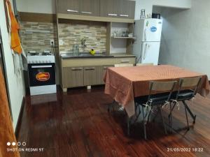 cocina con mesa, fogones y nevera en La Baquiana, en Mercedes