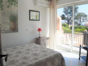 a bedroom with a bed and a large window at Villa in Sainte-Maxime near La Nartelle Beach in La Nartelle