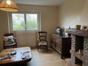 a living room with a table and a fireplace at Gîte cosy avec terrasse et WiFi - 2 ch, 4 pers à Besson - FR-1-489-355 in Besson