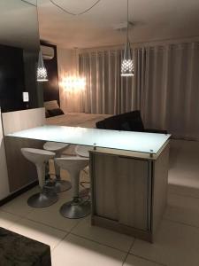 een woonkamer met een grote witte bar en een tafel bij Villas do Pratagy Temporada Limão in Maceió