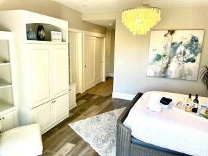 a bedroom with a bed and a chandelier at Spacious, Luxury Ocean Master Suite 2 BD With Kitchenette in San Diego