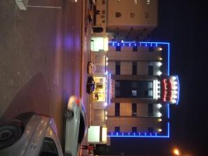 ein hohes Gebäude mit blauen Lichtern in der Nacht in der Unterkunft جواهر الشرق للوحدات السكنية in Riad