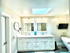 a white bathroom with a sink and a mirror at Spacious, Luxury Ocean Master Suite 2 BD With Kitchenette in San Diego