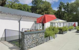 un paraguas rojo en una pared de piedra junto a un edificio en Nice Home In Wallendorf With Kitchen en Wallendorf