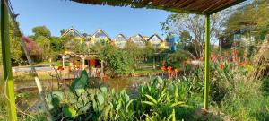 a garden with a pond and flowers and houses at Yellow Haven Lodge in Kampala