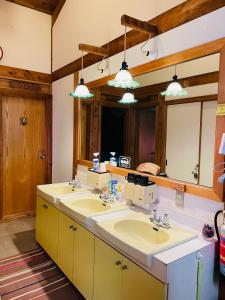 a bathroom with two sinks and a large mirror at Sanrinsha in Takamori