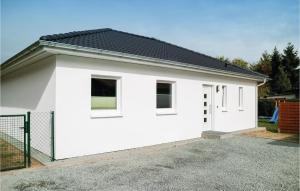 uma casa branca com um telhado preto em 2 Bedroom Stunning Home In Rostock-rvershagen em Rövershagen