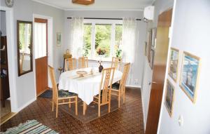 a dining room with a white table and chairs at Lovely Home In Mnsters With Kitchen in Mönsterås