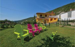 a row of colorful chairs sitting in the grass at 4 Bedroom Beautiful Home In Crni Kal in Črni Kal