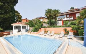 a swimming pool with white chairs next to a building at 2 Bedroom Amazing Apartment In Portoroz in Portorož
